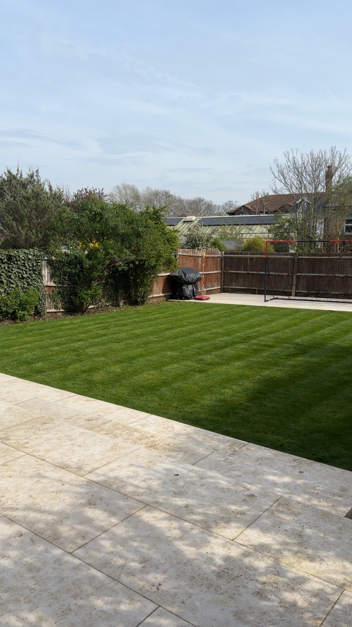Spacious residential garden with a manicured lawn and neat borders, ready for a professional gardening visit